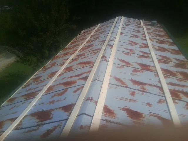 Rusted metal roof panels with new wood purlins before replacement — Storm Damage Roof Repair in Cicero by Roofing Brothers